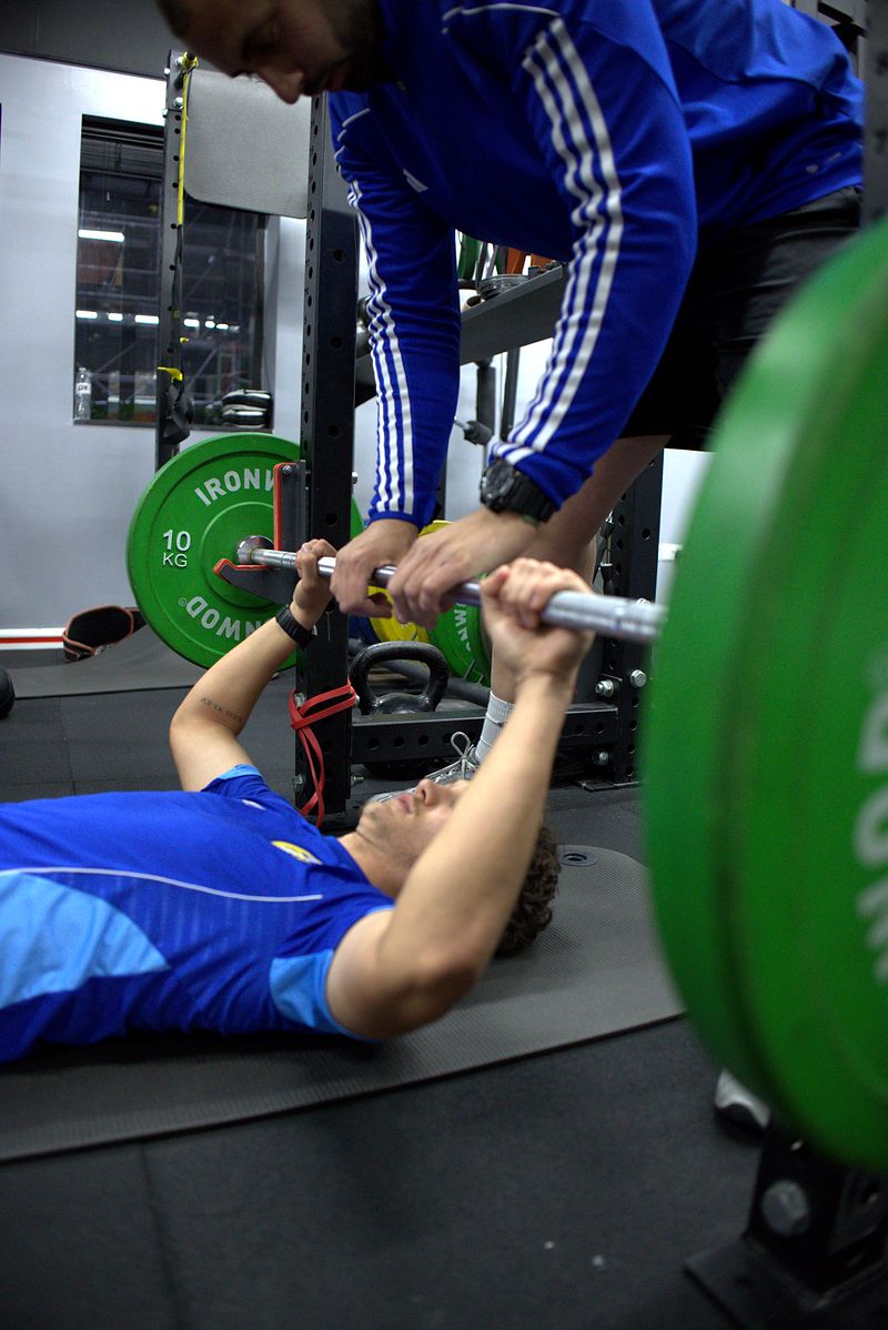 Edward Ibrovic-Fletcher bench pressing with Dion Tsolakis spotting